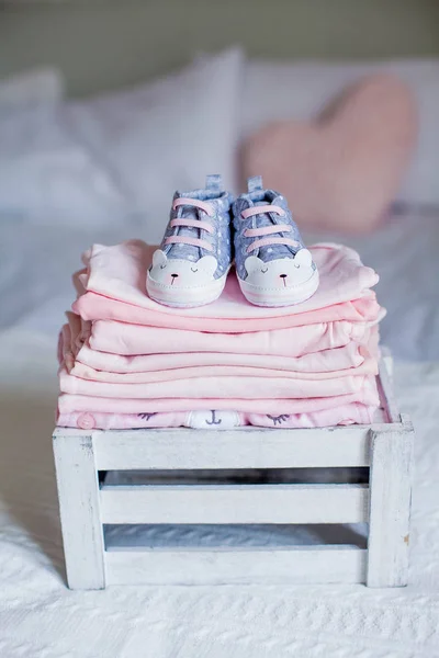 Children's shoes and clothes on the bed. Beautiful pink baby clothes. Newborn. Home cosiness. Baby. — Stock Photo, Image
