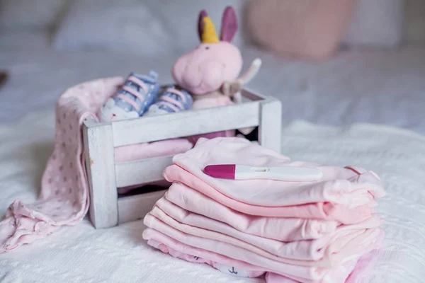 Детская обувь и одежда на кровати. Красивая розовая детская одежда. Новорожденный. Уют в доме. Ребенок . — стоковое фото