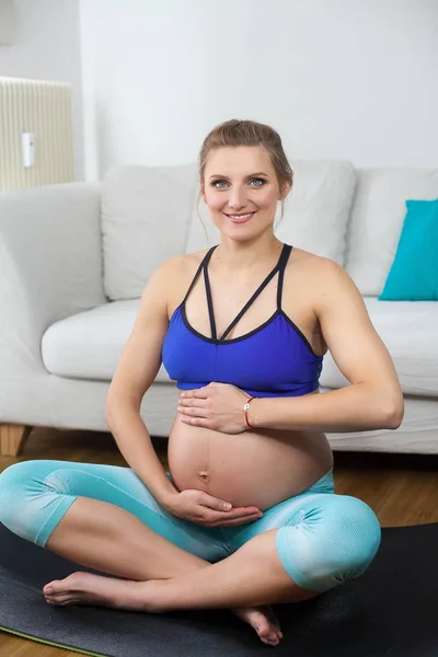 Genç, güzel ve hamile bir kadın hamile kadınlar için yoga devreye girer. Hamile kadınlar için spor. Genç hamile kadın. Sağlık. Hamile yoga. Annelik. — Stok fotoğraf