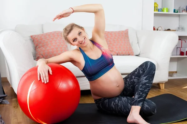 Genç, güzel ve hamile bir kadın hamile kadınlar için yoga devreye girer. Hamile kadınlar için spor. Sağlık. Hamile yoga. Annelik. — Stok fotoğraf