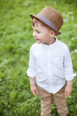 Sevimli küçük bir çocuk için 3 yıl Bahar parkta yürüyor. Sıcak bahar. Çiçek park. Bir cüruf içinde mutlu küçük sarışın çocuk portresi. Yaz.