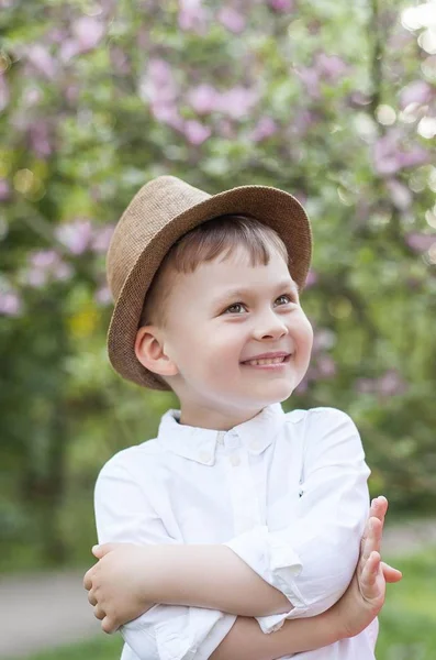 Milý chlapeček procházky v parku na jaře za 3 roky. Teplé jaro. Kvetoucí park. Portrét šťastný malý blonďák v strusky. Léto. — Stock fotografie
