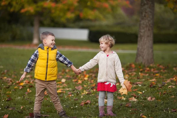 男の子は女の子を抱きしめる。明るい秋の服で幸せな子供の肖像画。暖かく明るい秋. — ストック写真