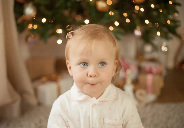 Niña linda de 2 años en pijama abre regalos en el árbol de Navidad. Navidad. Año Nuevo. Vacaciones. Acogedor . —  Fotos de Stock