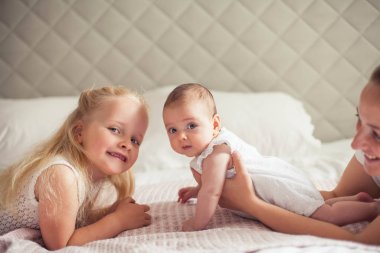 Genç ve güzel bir anne bir bebek doğuruyor. Küçük kız kardeşi küçük kız kardeşini öper. Bebek. Çocuk yatak odası.