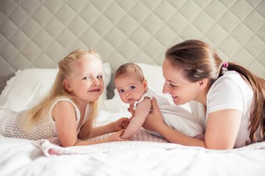 Genç ve güzel bir anne bir bebek doğuruyor. Küçük kız kardeşi küçük kız kardeşini öper. Bebek. Çocuk yatak odası.