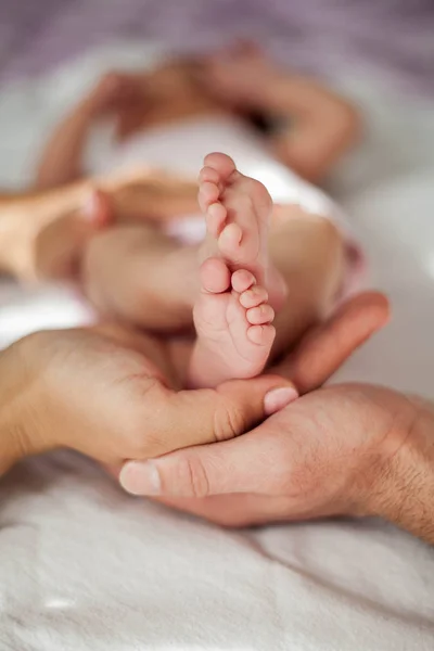 Mamma och pappa håller babybenen. Närbild. — Stockfoto