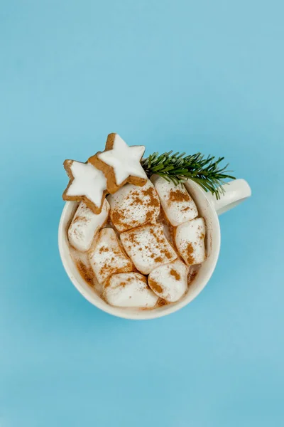 코코아와 마시멜로가 들어 있는 커다란 흰색 머그와 푸른 배경에 있는 계피입니다. 크리스마스 쿠키. 전통적 인 겨울 음료. — 스톡 사진