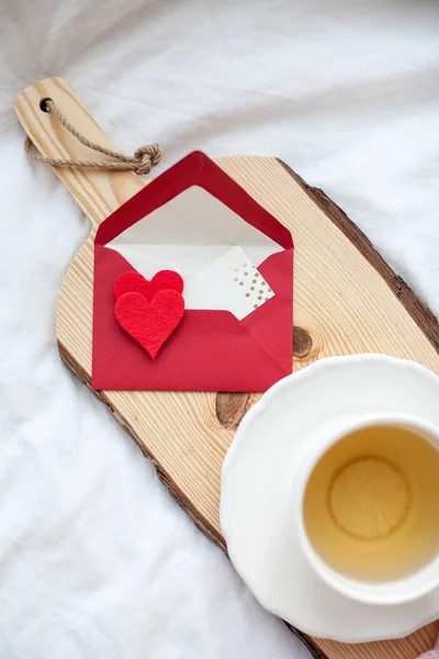 Hermosa taza blanca con té en la cama, cuadros de punto rosa, postal Feliz Día de San Valentín. Desayuno en la cama. Buenos días. Primavera. Acogedor . — Foto de Stock