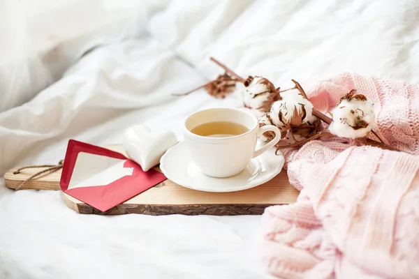 Hermosa taza blanca con té en la cama, cuadros de punto rosa, postal Feliz Día de San Valentín. Desayuno en la cama. Buenos días. Primavera. Acogedor . — Foto de Stock