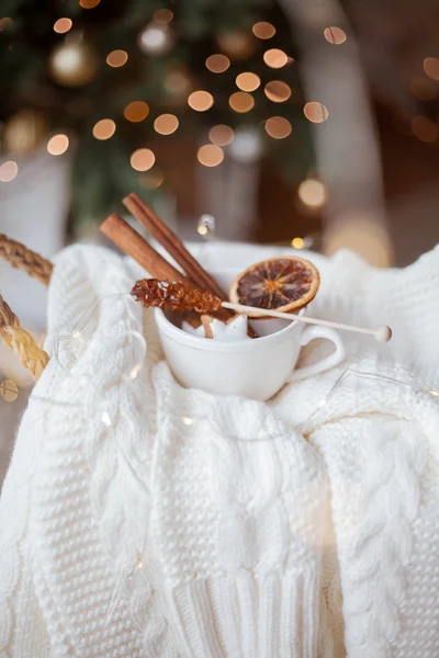 Плетеная корзина, вязаный свитер, сушеные цитрусовые, коричные палочки, рождественское печенье, рождественские огни. Уютный . — стоковое фото