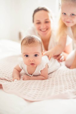 Genç ve güzel bir anne bir bebek doğuruyor. Küçük kız kardeşi küçük kız kardeşini öper. Bebek. Çocuk yatak odası.