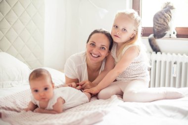 Genç ve güzel bir anne bir bebek doğuruyor. Küçük kız kardeşi küçük kız kardeşini öper. Bebek. Çocuk yatak odası.