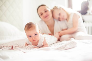 Genç ve güzel bir anne bir bebek doğuruyor. Küçük kız kardeşi küçük kız kardeşini öper. Bebek. Çocuk yatak odası.