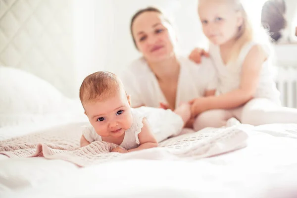 Genç ve güzel bir anne bir bebek doğuruyor. Küçük kız kardeşi küçük kız kardeşini öper. Bebek. Çocuk yatak odası. — Stok fotoğraf
