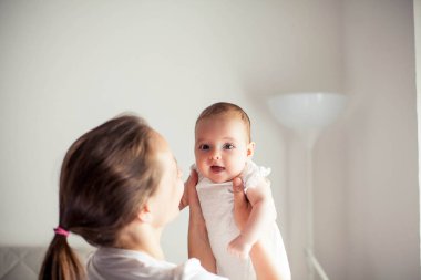 Genç ve güzel bir anne bir bebek doğuruyor. Annem bebeğini öper. Çocuk yatak odası.