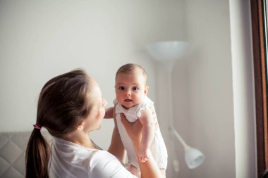 Genç ve güzel bir anne bir bebek doğuruyor. Annem bebeğini öper. Çocuk yatak odası.