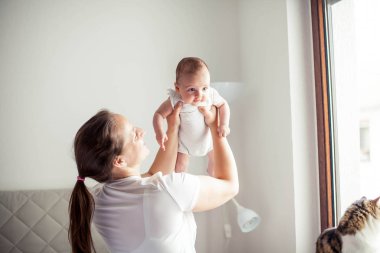 Genç ve güzel bir anne bir bebek doğuruyor. Annem bebeğini öper. Çocuk yatak odası.