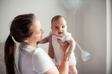Genç ve güzel bir anne bir bebek doğuruyor. Annem bebeğini öper. Çocuk yatak odası.