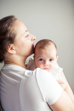 Genç ve güzel bir anne bir bebek doğuruyor. Annem bebeğini öper. Çocuk yatak odası.