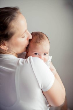 Genç ve güzel bir anne bir bebek doğuruyor. Annem bebeğini öper. Çocuk yatak odası.