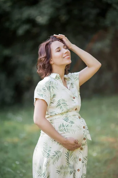 Portrait of a beautiful young pregnant woman in eco dress. Motherhood. A family.