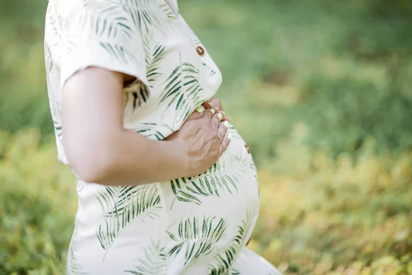 Närbild. Porträtt av en vacker ung gravid kvinna i eko klänning. Moderskap. En familj. Sommar. — Stockfoto