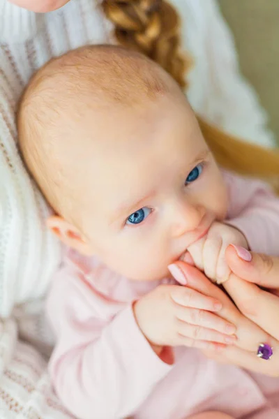 Primer plano. Hermosa joven madre sostiene las manos de su pequeña hija. Nena. Recién nacido . — Foto de Stock