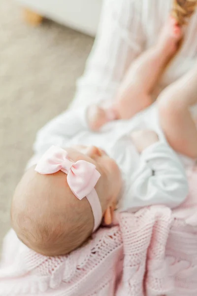 美しい若い母親は彼女の小さな娘の足を手に持っています 赤ちゃんよ 新生児 — ストック写真