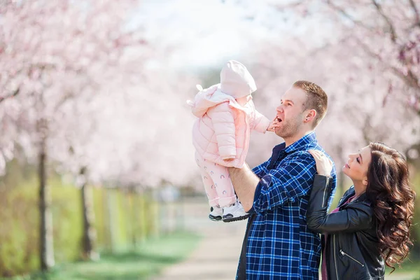 Genç Ebeveynler Kollarında Küçük Güzel Bir Kız Çocuğu Tutuyorlar Çiçekli — Stok fotoğraf