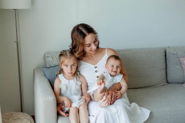 Genç mutlu anne ve kızları evin içinde. Anneler Günü.