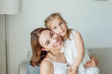 Genç mutlu anne ve kızları evin içinde. Anneler Günü. Samimi.