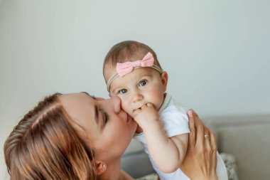 Genç mutlu anne ve kızları evin içinde. Anneler Günü. Samimi.