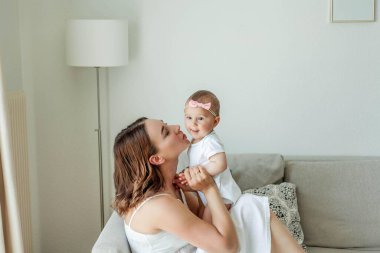 Genç mutlu anne ve kızları evin içinde. Anneler Günü. Samimi.