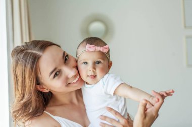 Genç mutlu anne ve kızları evin içinde. Anneler Günü. Samimi.