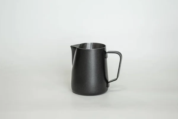 Kahve yapmak için siyah metal sürahi. Barista aleti. Süt sürahisi. beyaz arkaplan
