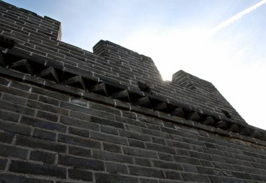 The Great Wall of China. The sun is seen just above the side of the wall at this section of the Great Wall at Juyongguan. Great Wall of China near Beijing. Great Wall of China, Juyongguan section, Beijing, China, UNESCO, mountains, watchtowers clipart