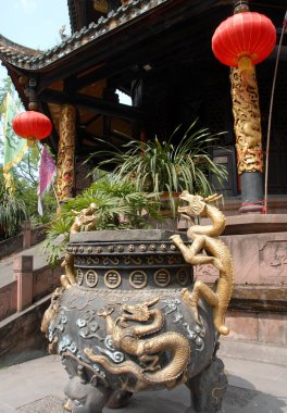 Eight Trigrams Pavillion at the Green Ram Temple or Green Goat Temple in Chengdu China. Close up of an urn decorated with dragons. It's also known as the Green Ram or Goat Monastery. It's a Chinese Taoist temple with religious signs in Chinese. clipart