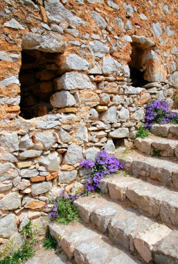 Palamidi Kalesi ya da Nafplio 'da mor çiçekli bir kale. Şato Nafplio 'nun üzerindeki bir tepede. Nafplio, Yunanistan 'ın Mora bölgesinde eski bir şehirdir. Nafplio, Nafplion, Nauplio ve Nauplion olarak da bilinir.
