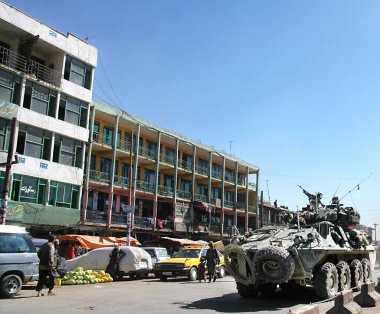 Afganistan 'da Kabil. Afganistan, Kabil 'de bir cadde boyunca zırhlı bir araç sürüyor. Siviller günlük hayatlarına devam ediyorlar. Zırhlı araç, tank, savaş, sokak, halk, Kabil Afganistan