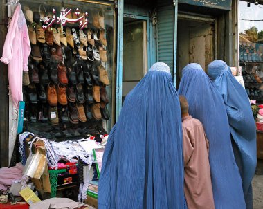 Afganistan 'da Kabil. Afganistan, Kabil 'de bir ayakkabı mağazasının önünde duran Afgan kadınlar. Kadınlar mavi burka (burka) giyiyorlar. Mavi çarşaf (burka) Afganistan 'da gelenekseldir..