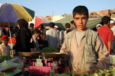 Afganistan 'da Kabil. Markette sebze satan genç bir Afgan. Bu Kabil pazarı, Afganistan. Afganistan, Kabil 'de renkli bir pazar. İnsan, piyasa duruşu, ölçekler