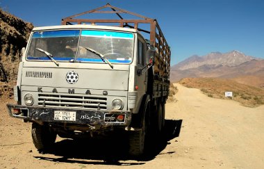 Afganistan 'da Kabil ve Bamyan (Bamiyan) arasındaki yol. Tozlu bir yolda, Kabil 'den Bamyan' a (Bamiyan) güney rotasında bir Kamaz kamyonu. Kamaz kamyonu, toprak yol, ulaşım, Orta Afganistan.