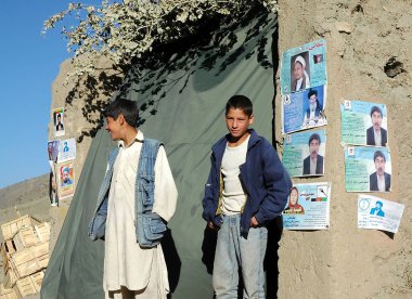 Afganistan 'da Kabil ile Bamyan (Bamiyan) arasındaki köy. Afganistan 'da Kabil ve Bamyan arasında bir evin önünde duran iki Müslüman adam. Erkekler, Afgan köyü, Afganistan.