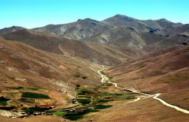 Afganistan 'da Kabil ve Bamyan (Bamiyan) arasındaki dağ manzarası. Uzak bir köye giden tozlu bir yol. Afganistan 'ın orta kesiminde Kabil ve Bamyan (Bamiyan) arasındaki güney yolunda çekildi..