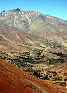 Afganistan 'da Kabil ve Bamyan (Bamiyan) arasındaki dağ manzarası. Uzak bir köye giden tozlu bir yol. Afganistan 'ın orta kesiminde Kabil ve Bamyan (Bamiyan) arasındaki güney yolunda çekildi..