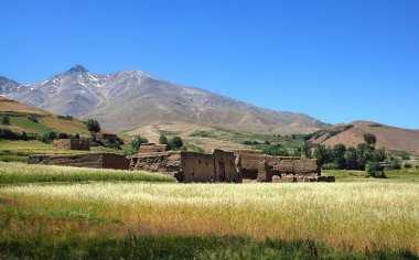 Tarlada yıkılmış bir bina. Afganistan 'da Kabil ve Bamyan (Bamiyan) arasındaki dağ manzarası. Afganistan 'ın orta kesiminde Kabil ve Bamyan (Bamiyan) arasındaki güney yolunda çekildi..