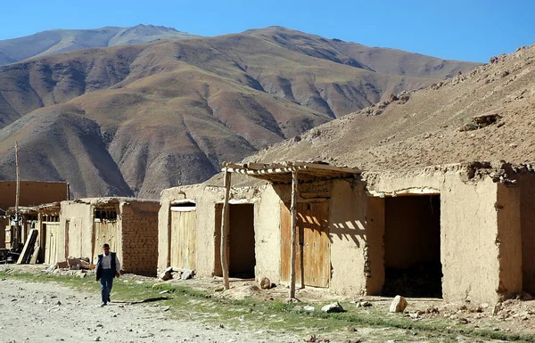 アフガニスタンのカブールとバーミヤン バーミヤン の間の村 男はカブールとバーミヤンの間の南のルートにアフガニスタン中央部のこの遠隔地の村を通って道路に沿って歩く — ストック写真