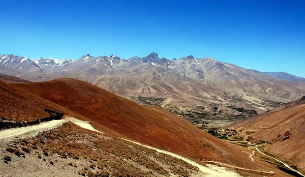 Afganistan 'da Kabil ve Bamyan (Bamiyan) arasındaki dağ manzarası. Uzak bir köye giden tozlu bir yol. Afganistan 'ın orta kesiminde Kabil ve Bamyan (Bamiyan) arasındaki güney yolunda çekildi..