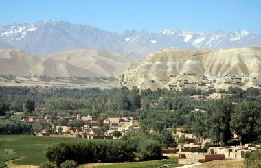 Orta Afganistan 'da Bamyan (Bamiyan). Kasabayı, ağaçları, tarlaları ve karlı dağları gösteren Bamyan (Bamiyan) Vadisi üzerinde bir manzara. Kasaba Afganistan 'ın ünlü UNESCO Buda' larına ev sahipliği yapar.